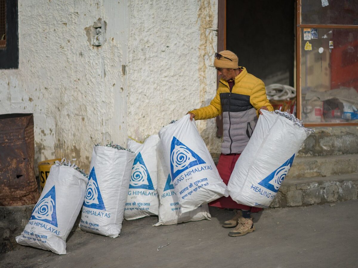 A team loading bags of collected waste at dusk